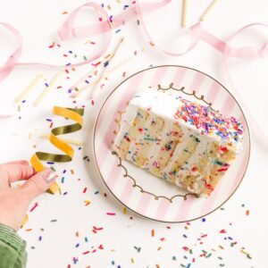 person holding white and pink floral ceramic plate
