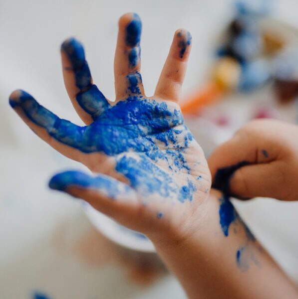 person with blue paint on hand