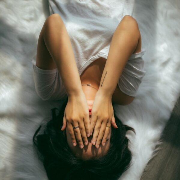 a woman holds her hands over her face