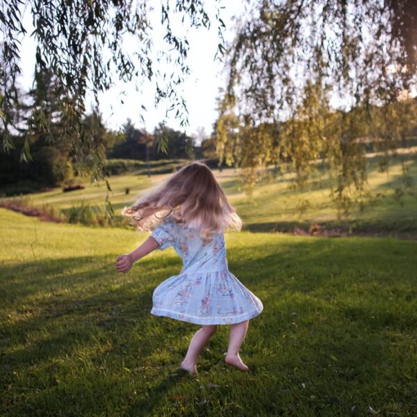 girl dancing on green grass field