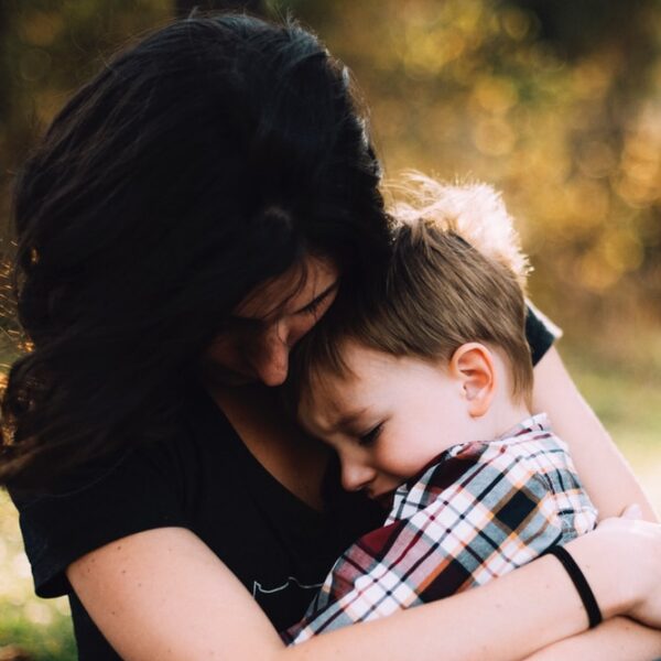 woman hugging boy on her lap