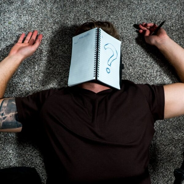 person in black shirt holding white paper