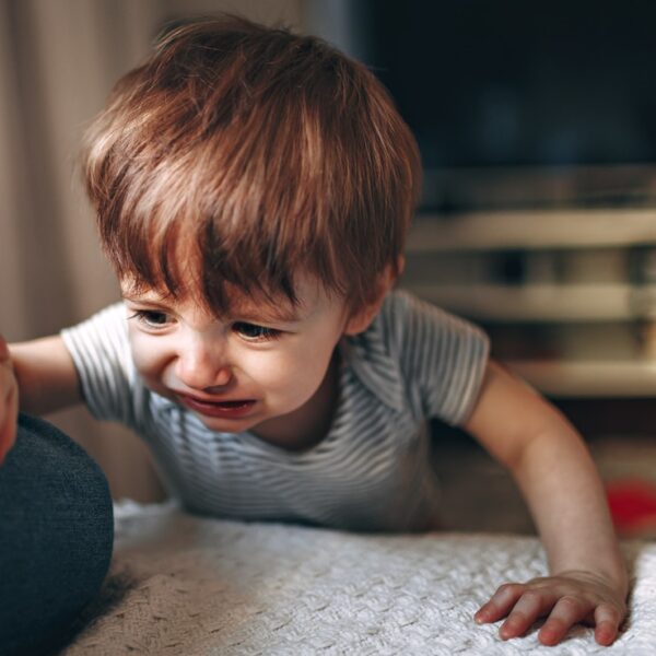 boy in gray and white striped shirt sitting on floor