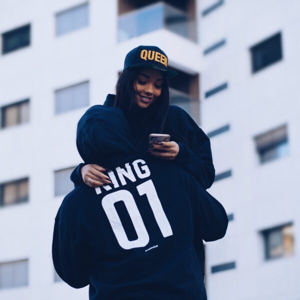 man carrying woman while holding phone