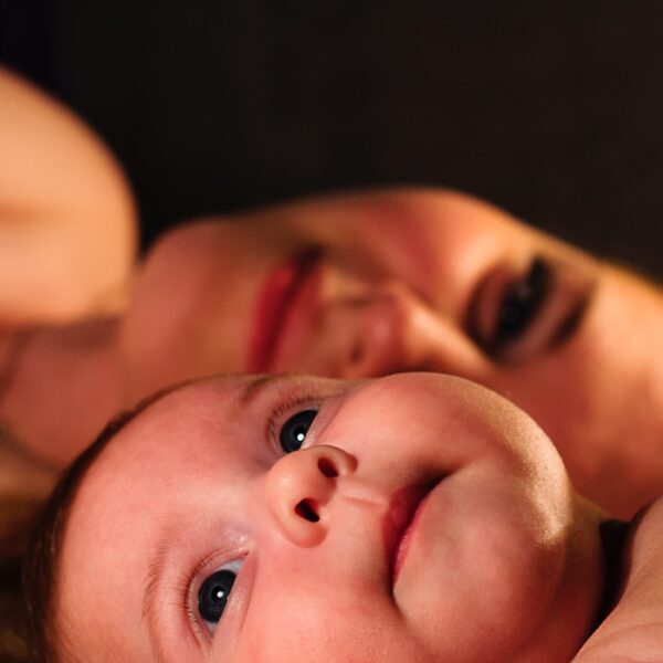 shallow focus photography of baby beside woman
