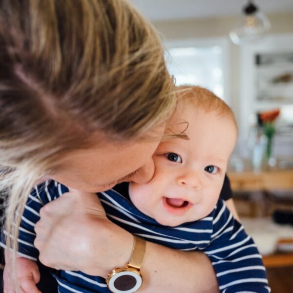woman carrying baby in striped shirt