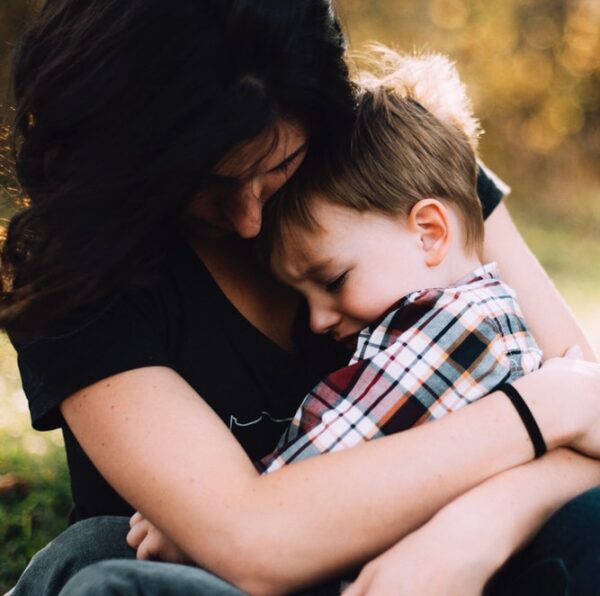 woman hugging boy on her lap