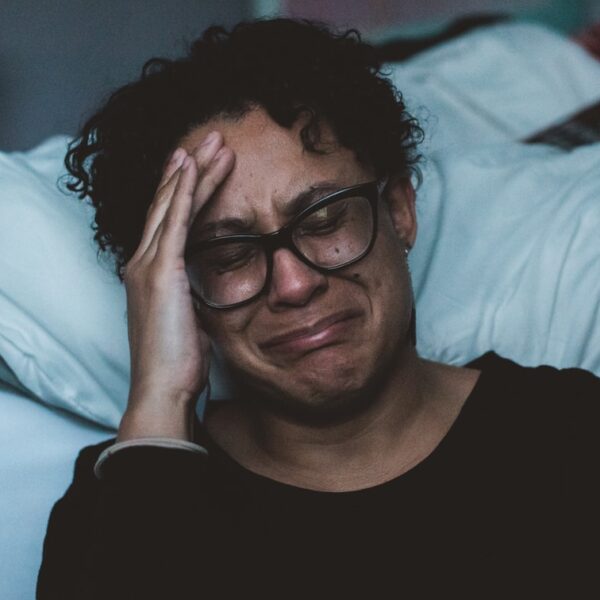 person crying beside bed