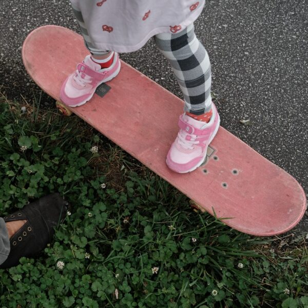 person in brown pants and black shoes standing on red concrete floor