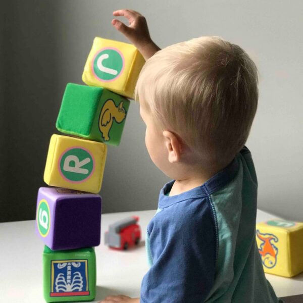 boy playing cube on white wooden table
