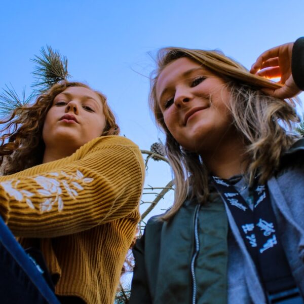 two women posing and looking down at the camera