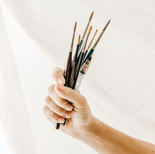 person holding paint brush and brush