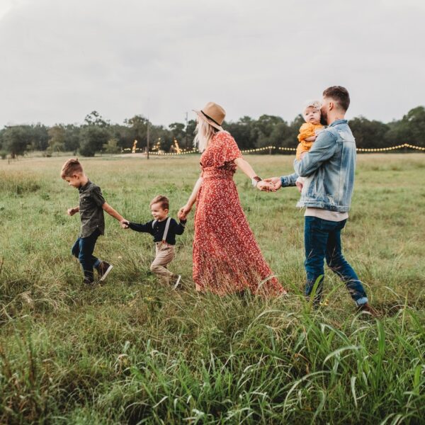 woman holding man and toddler hands during daytime