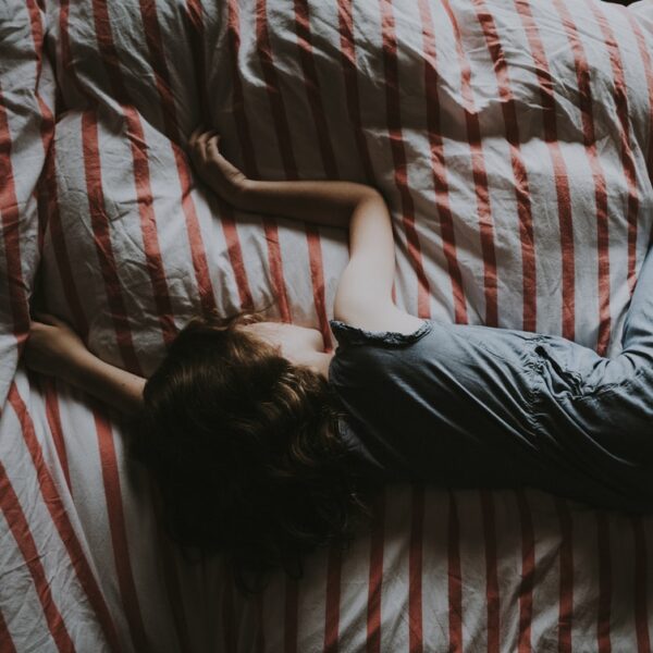 kid sleeping on red and gray bed