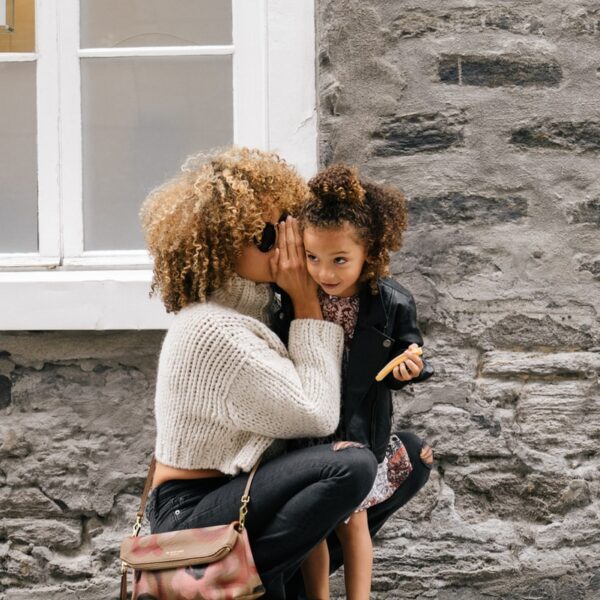 woman wearing white sweater carrying a daughter